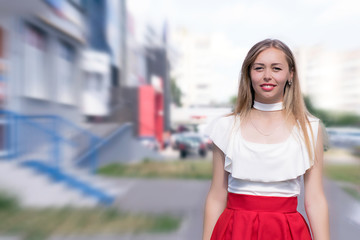 Young pretty girl standing on the street. Blured background