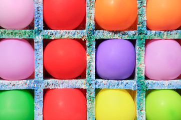 Multicolored inflatable balls in cells. Shooting on the balls. Close-up.