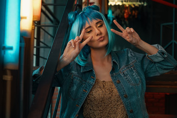 Cheerful girl making duck face  while showing victory sign