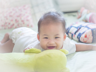 infant baby lying down on the bed and smiling