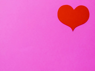 Red paper hearts on a pink paper background