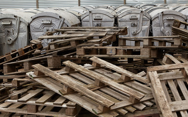 Stack of Wooden Pallets in Front of Metal Garbage Containers