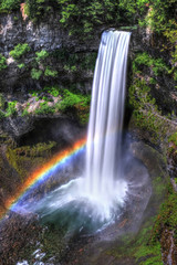 Rainbow over waterfalls in sunny day. Brandywine Falls near Whistler Village. Vancouver. Beautiful British Columbia. Canada.