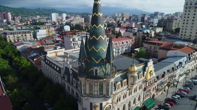 Flying camera moves around the tower with an astronomical clock in the center of Batumi, in Europe square. Beautiful panoramic view of the city. Aerial view.