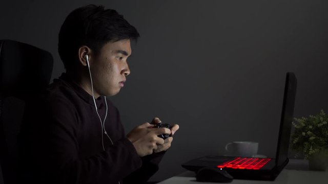Stressed depressed young man using joystick to playing games