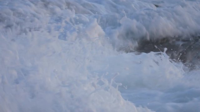 sea wave hit the rock shore sand beach seascape. Backdrop is colorful parasail