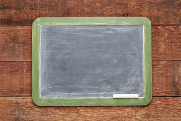 blank slate blackboard against rustic wood