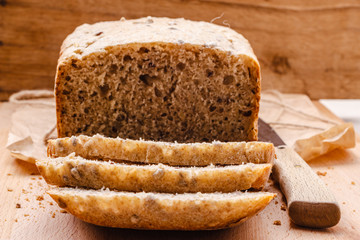 Fototapeta na wymiar Sliced whole wheat bread on cutting board