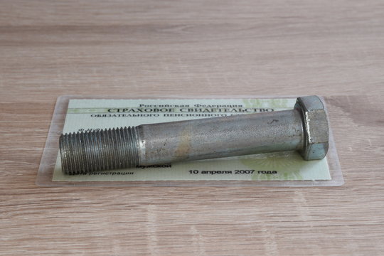 A large screw put on a russian pension insurance certificate (SNILS)
