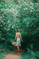 young woman in forest on a background of green foliage. Fashion for women