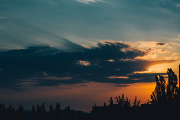 Landscape with dramatic light - beautiful golden sunset with saturated sky and clouds.