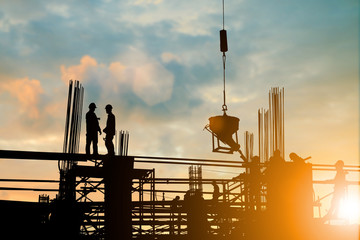 Silhouette of engineer and construction team working at site over blurred background sunset pastel for industry background with Light fair.Create from multiple reference images together.