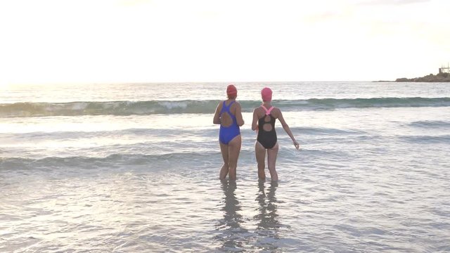 Senior women going for early morning swim at the beach
