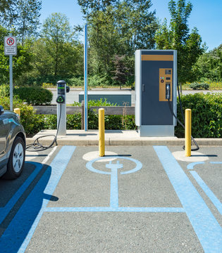Electric vehicle charging stations. Quick charge station with electric car parked on side