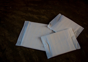 A sanitary napkin or sanitary towel or sanitary pad or menstrual pad is an absorbent item on dark background