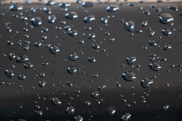 Closeup photo of water drop on the car. The reflected photo of water and light.