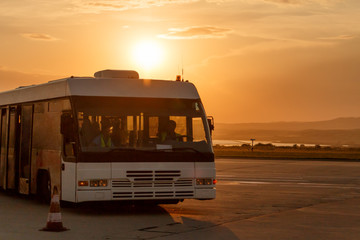 Shuttle buses at the stop of the airport in the rays of the setting sun