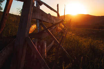 The sun is stunning sunset over the mountains of the Altai. fence. Meadows