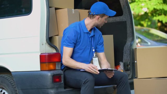 Busy delivery workman counting parcels, stocktaking checklist, part-time job