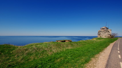 Estońskie wybrzeże Bałtyku - piękny błękit nieba i morza przy średniowiecznej latarni...