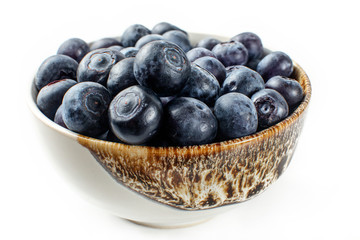Closeup photo - small bowl of blueberries, isolated on white background.