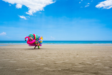 Obraz premium A dealer in inflatable swimming circles walks along the beach