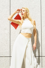 Fashion woman white outfit with red handbag