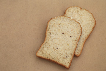 Whole grain bread on natural brown texture background.
