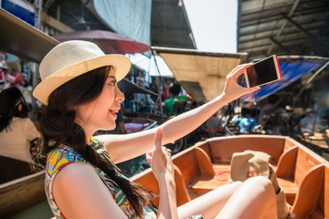 Obraz na płótnie Canvas Woman taking selfie with floating market.