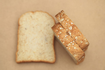 Whole grain bread on brown wood background.