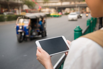 woman look at the digital pad beside the road