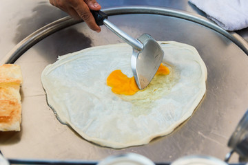 Chef making roti and egg.