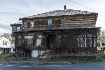 Old wooden rotten house covered plant and woods