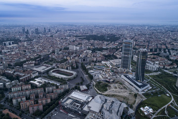 Fototapeta na wymiar Aerial view of Milan (Italy) at dawn. On the right the new two skyscrapers of the CityLife district and the building site of the third tower.