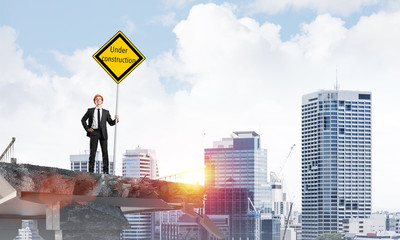 Confident engineer holding street safety sign.