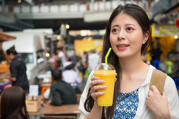 woman drinking the mango juice in the street