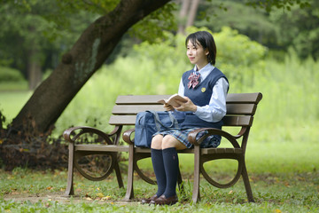 ベンチで本を読む女性