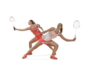 Young women playing badminton over white background