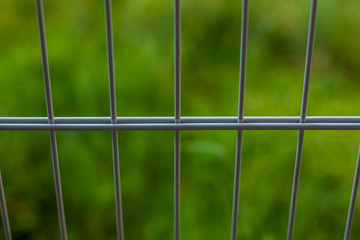 soft focus metal fence on green background concept with empty space for copy or text
