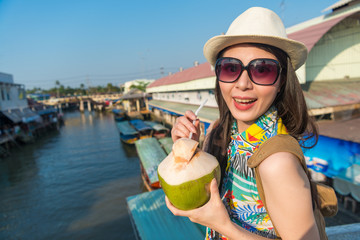 woman holding a coconut and sip with a straw