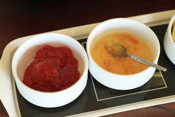 Strawberry jam and marmalade in white bowl.