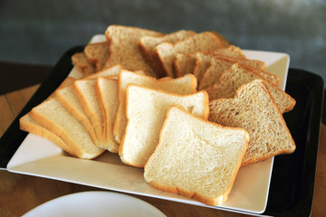 White and brown bread sliced on white dish.