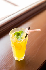 glass of lemonade. glass of orange juice. a glass with a straw. lemonade with mint