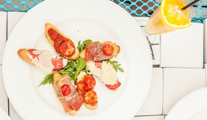 Canapes with prosciutto, cherry tomato and rocket salad