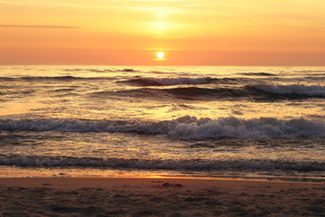 Naklejka na ściany i meble Sea waves at sunset. Baltic sea beach in Palanga.