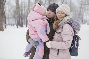 Happy loving caucasian family of mother father and daughter play, having fun in winter snowy park