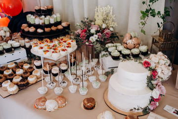 The buffet table with sweets and wedding cake