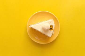 Sponge cake with hazelnut, cheese-coconut cream on natural cream and marmalade layer of passion fruit isolated on yellow background.