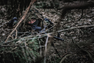 Fototapeta na wymiar Airsoft player in eastern uniform during playtime in forest
