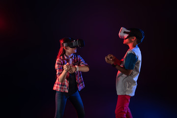 Interesting game. Concentrated little girl and a boy wearing VR headsets and playing